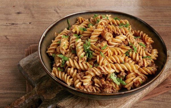 Pasta in the navy, pasta with minced meat, plate on a wooden table, homemade, fusilli pasta,