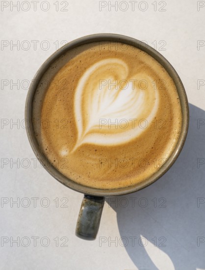 Cappuccino with heart pattern in the crema, coffee cup on a light-coloured background, Copenhagen,