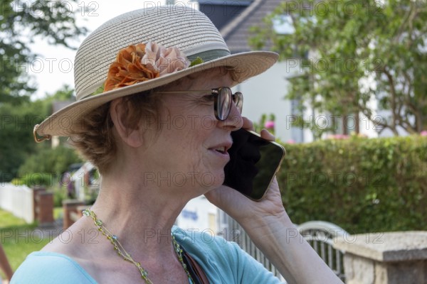 Elderly woman on the phone with smartphone, Wustrow, Darß, Mecklenburg-Vorpommern, Germany, Europe