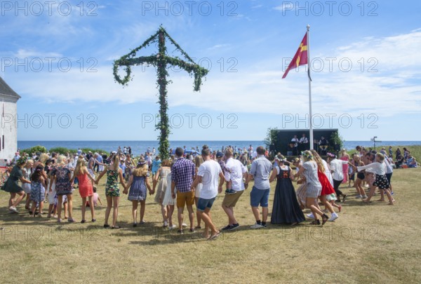 Traditional midsummer celebration with dancing around the maypole at Smygehuk, Smygehamn,