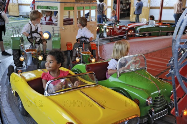 Boys and girls on car in carousel, old, historic Oktoberfest, Oktoberfest, Munich, Upper Bavaria,
