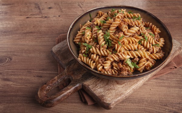 Pasta in the navy, pasta with minced meat, plate on a wooden table, homemade, fusilli pasta,