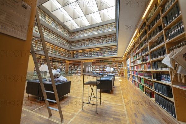 Large modern library with well-stocked bookshelves, ladders and cosy reading area, Weimar, Germany,