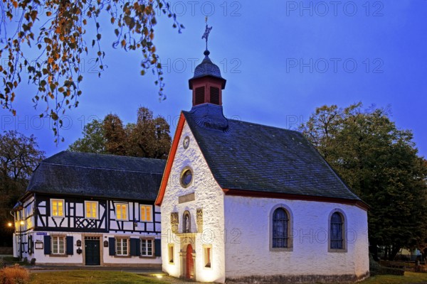 Illuminated St Mary's Chapel in the evening with half-timbered house, Rhöndorf, Bad Honnef, North