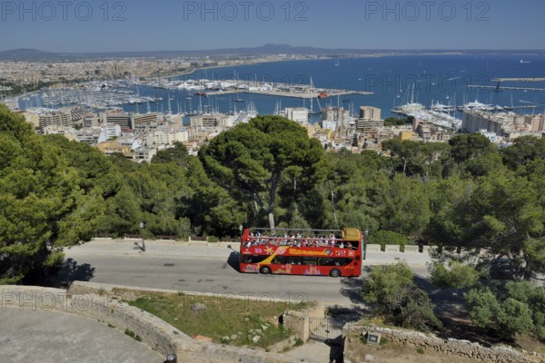 Tourist bus at Bellver Castle, Palma de Mallorca behind, Majorca, Balearic Islands, Spain, Europe