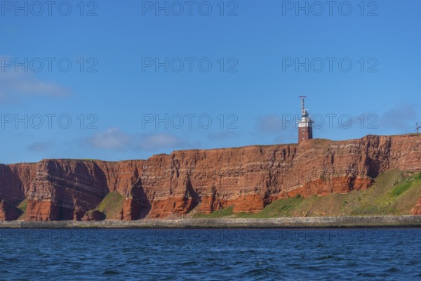 Red mottled sandstone cliff edge, Heligoland high sea island, lighthouse, geology, scree, blue sky,