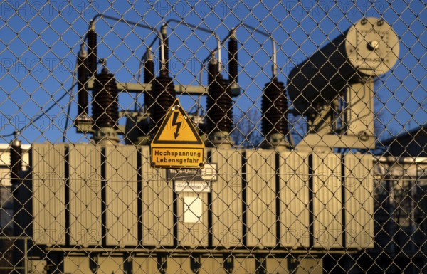 High-voltage warning sign, danger to life, in front of capacitors in substation, transformer,