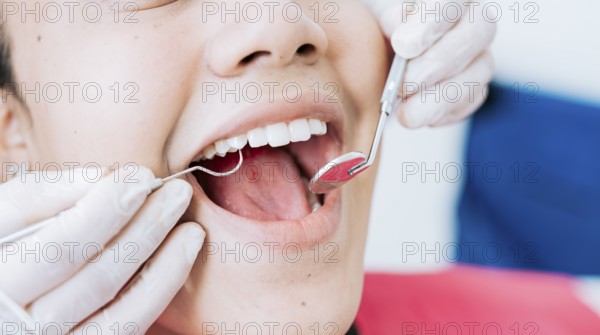 Hands of a specialist dentist cleaning the teeth of a female patient. Close up of dentist hands