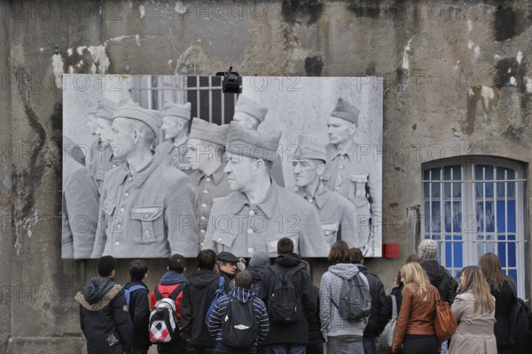 Students with guide in front of the picture of the political prisoners at Fort Breendonk, Belgium,