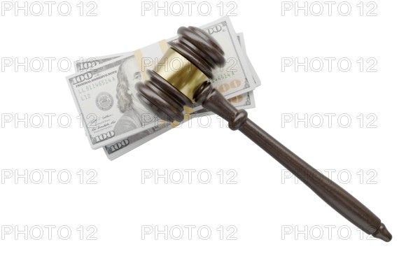Overhead of gavel resting on stacks of thousands of dollars isolated on a white background