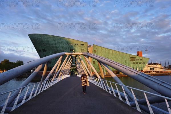 AMSTERDAM, NETHERLANDS, MAY 9, 2017: NEMO Science museum and Mr. J. van der Veldebrug bridge. It is