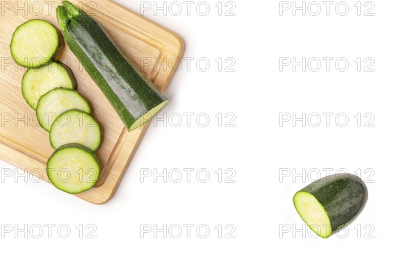 Courgettes (Cucurbita pepo), cut open, on wooden board, on white, copy room