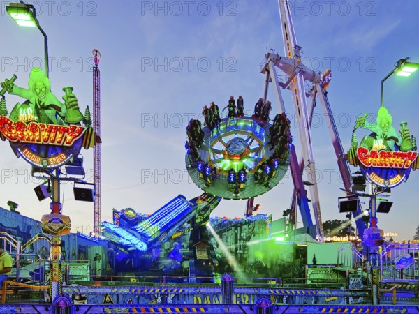 People on the illuminated carousel Mr Gravity in the evening, Cranger Kirmes, Herne, Ruhr area,