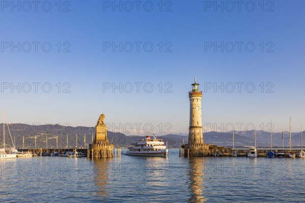 Bavarian Lion, an excursion boat and the lighthouse in the harbour, Lindau Island, Lindau, Lake