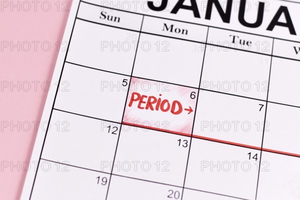 Female period concept with calendar date with period start marked with red word