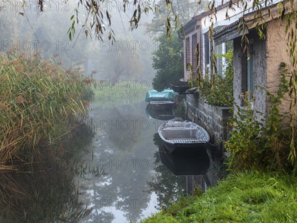 Autumn mist and lonely barges on the Spreewald river, between reeds and the edge of the village,