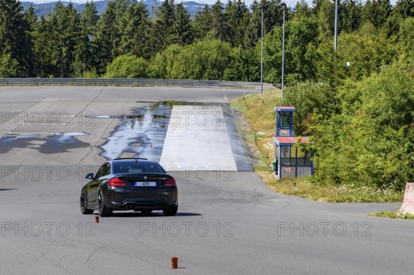 BMW M2 sports car slaloms retains control of vehicle during driving school driving safety training,