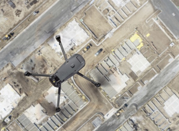 Unmanned aircraft system quadcopter drone UAV in the air over construction site.