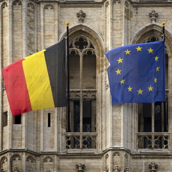 Belgian national flag and European flag in front of the baroque façade of the town hall, Hôtel de