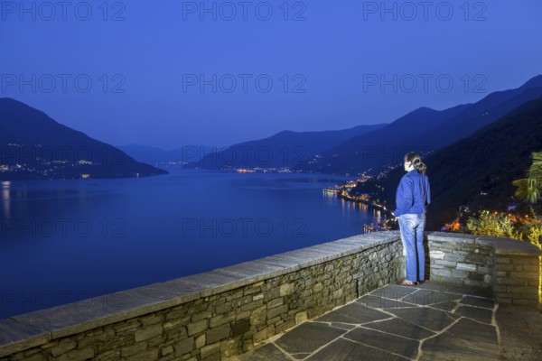 Woman Enjoy Panoramic View over Alpine Lake Maggiore with Mountain in Blue Hour in Ronco Sopra