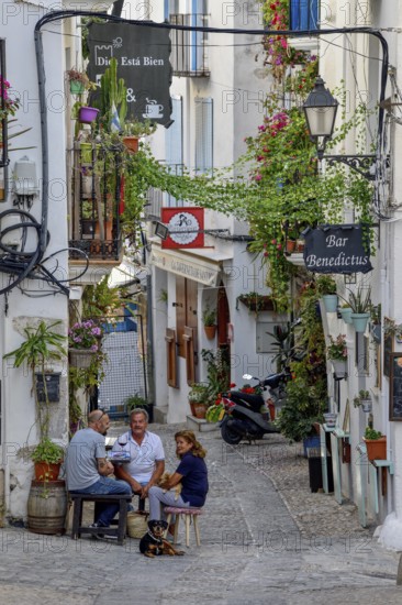 People in a sidewalk café in the old town of Peñíscola, Castellón province, Costa del Azahar,