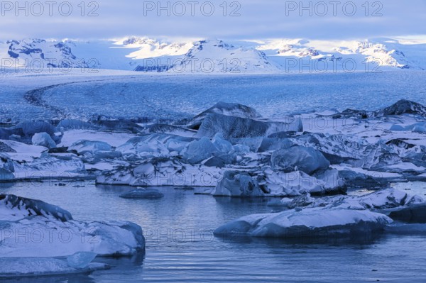 Snow-covered icebergs in the glacier lagoon Jökullsarlon, Breidamerkurjökull in the background,