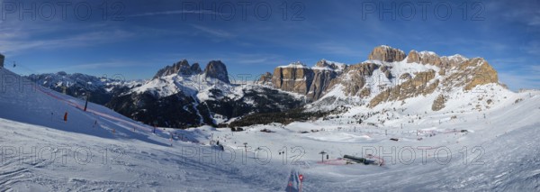 Panorama of a ski resort piste with people skiing in Dolomites in Italy. Ski area Belvedere.