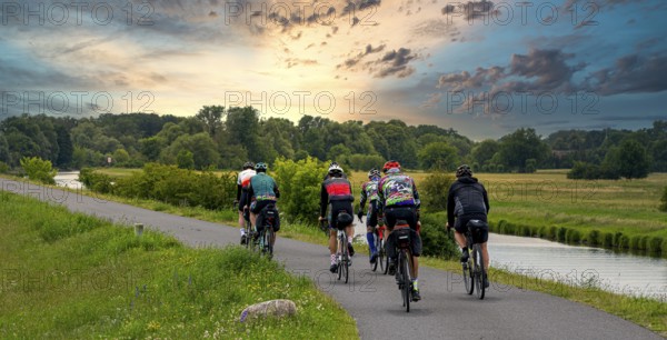 Cyclist on a cycle path by the river, landscape in the Lower Oder Valley National Park, Criewen,