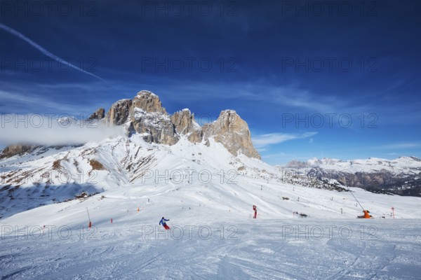 View of a ski resort piste with people skiing in Dolomites in Italy