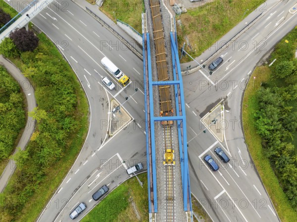 Railway bridge over road crossing with passing cars, track construction, rail delivery for Hermann