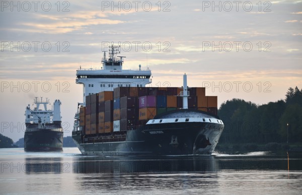 Container ship Nordic Porto sailing at sunrise in the Kiel Canal, Kiel Canal, Schleswig-Holstein,