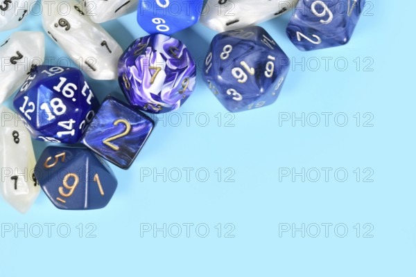 Different roleplaying RPG dice in upper corner of blue background with blank copy space
