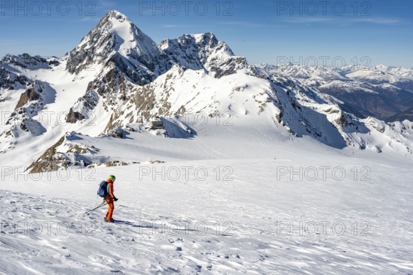 Mountaineer exploring a snow-covered landscape with impressive mountain peaks in the background,