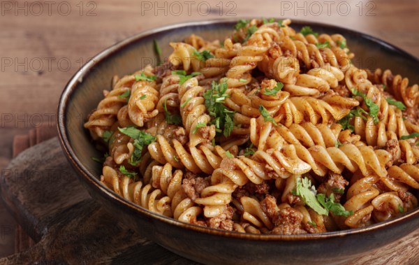 Pasta in the navy, pasta with minced meat, plate on a wooden table, homemade, fusilli pasta,