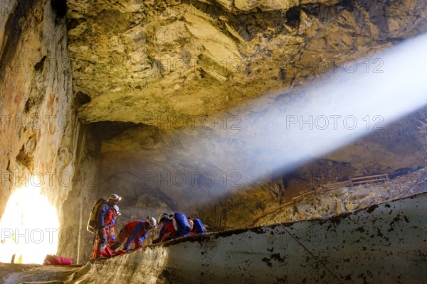 Sunbeam shines into the cave, cave rescuers from the Bavarian Mountain Rescue Service rescue an