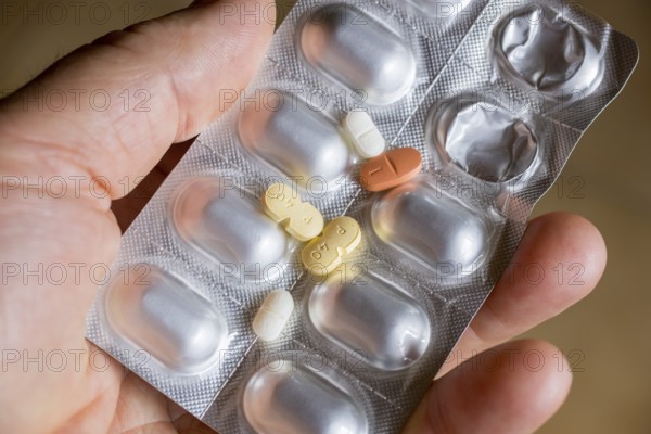 Hand holding a blister pack with tablets