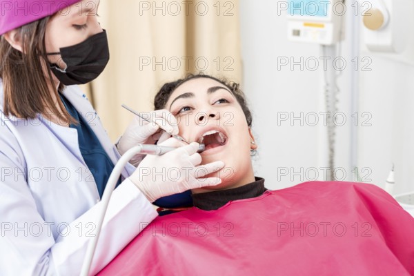 View of a dentist cleaning a patient mouth with a drill. Stomatologist cleaning a patient's teeth,