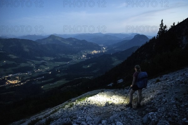 Female mountaineer hiking at night with a torch, Kaisergebirge, Wilder Kaiser, Kitzbühel Alps,