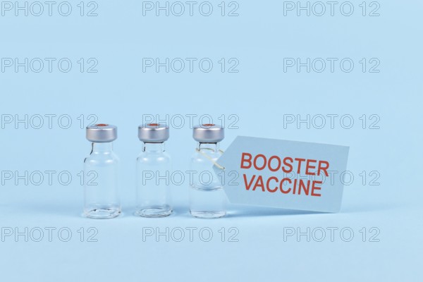 Corina virus booster vaccination concept with vial and syringe on blue background