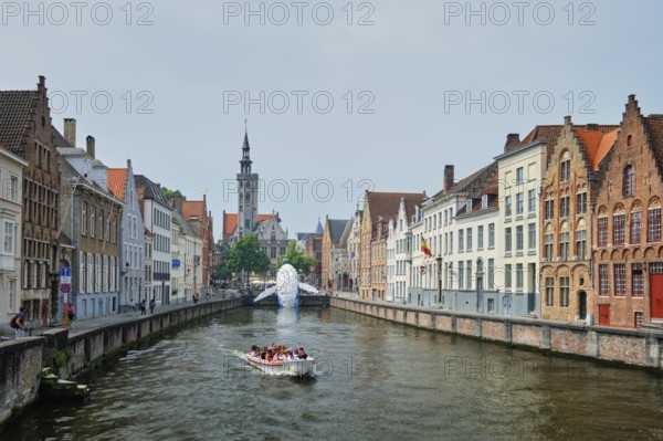 BRUGES, BELGIUM, MAY 29, 2018: Tourist boat in canal between old houses with The Bruges Whale