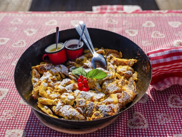 Kaiserschmarrn with decoration in a rustic pan on a tablecloth, South Tyrol, Italy, Europe