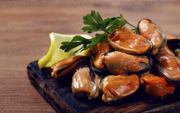 Mussels without shell, boiled, mussels, peeled, on a chopping board, with lemon and parsley,