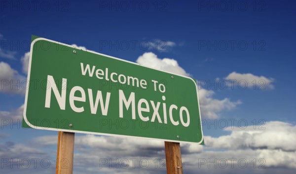 Welcome to new Mexico green road sign over blue sky with some clouds