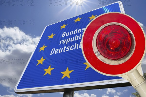 Symbolic image of the asylum debate: trowel in front of a border sign of the Federal Republic of