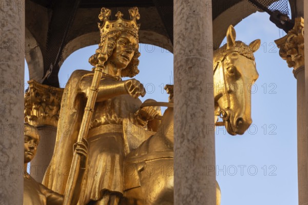 A golden sculpture of a crowned king on a horse, surrounded by columns, Golden Rider, Magdeburg,