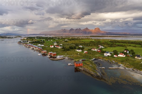 Boathouses of the village Herøy, behind the mountain range Seven Sisters, light mood, island Herøy,