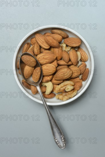 Almonds and walnuts in shell with spoon, various nuts