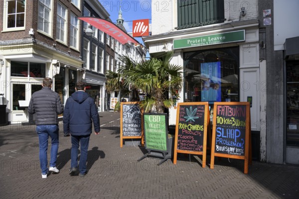 Passers-by in front of a cannabis shop in the pedestrian zone of The Hague, Holland, Netherlands