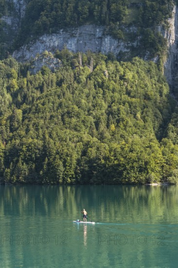 Stand-up paddler on Lake Klöntal, Canton Glarus, Switzerland, Europe