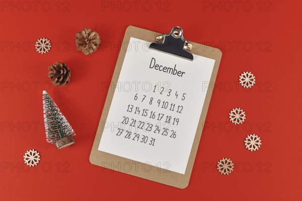 Christmas flat lay with clipboard with calendar sheet for month December surrounded by small